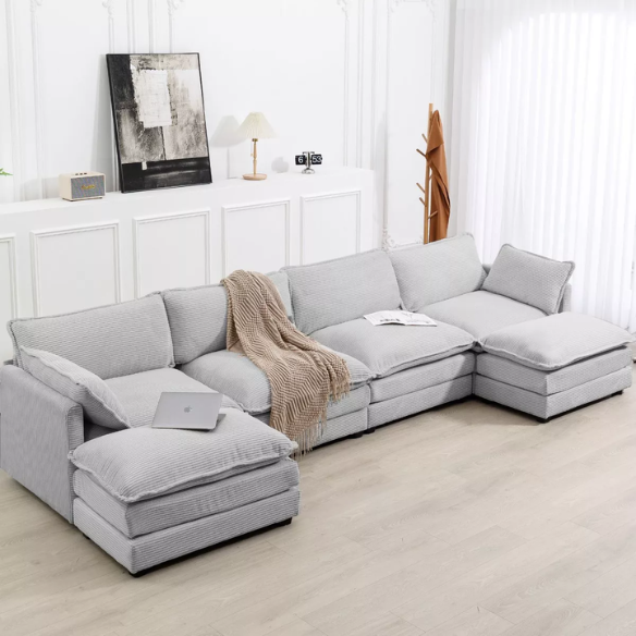 Light grey modular 4-seat sectional sofa with two matching ottomans, upholstered in soft corduroy fabric with high-resilience cushions and a durable wood and metal frame.