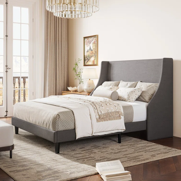 Light grey linen upholstered queen platform bed with wingback headboard, tapered black legs, and slatted support – no box spring needed
