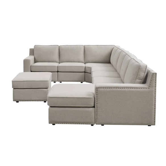 Spacious light taupe U-shaped sectional sofa with reversible configuration, removable cushions, nailhead trim, and matching ottoman—seats up to 8.
