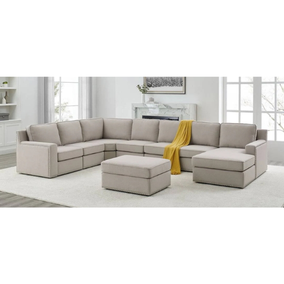 Spacious light taupe U-shaped sectional sofa with reversible configuration, removable cushions, nailhead trim, and matching ottoman—seats up to 8.