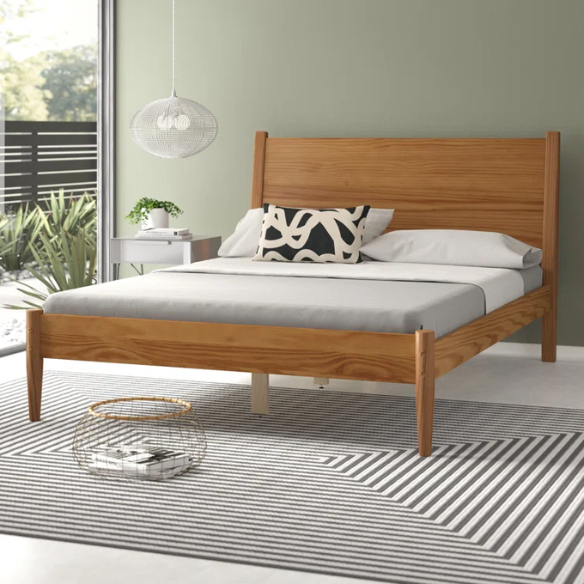 Mid-century modern full-size solid wood platform bed in medium light brown with rectangular headboard and tapered legs
