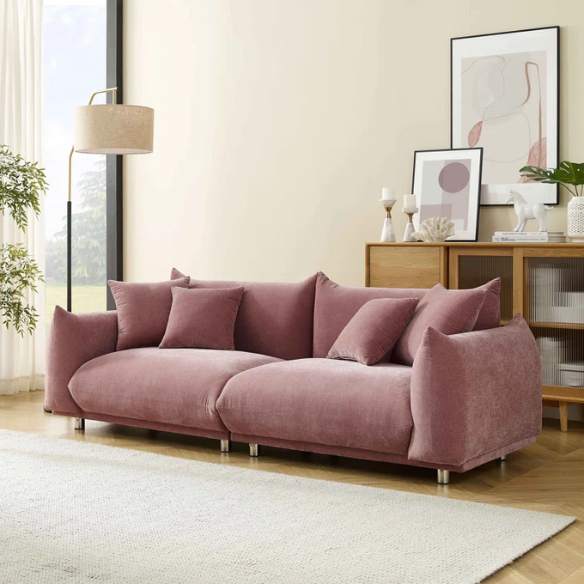 Modern dusty rose upholstered sofa with deep seating and chrome-finished legs, featuring four matching accent pillows—ideal for soft, stylish living spaces.
