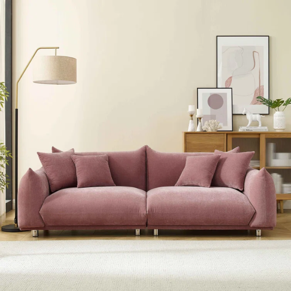 Modern dusty rose upholstered sofa with deep seating and chrome-finished legs, featuring four matching accent pillows—ideal for soft, stylish living spaces.