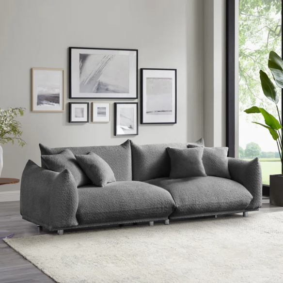 Modern 88.9-inch grey upholstered sofa with deep seat, rounded arms, chrome legs, and four matching accent pillows – ideal for contemporary living rooms or apartments.