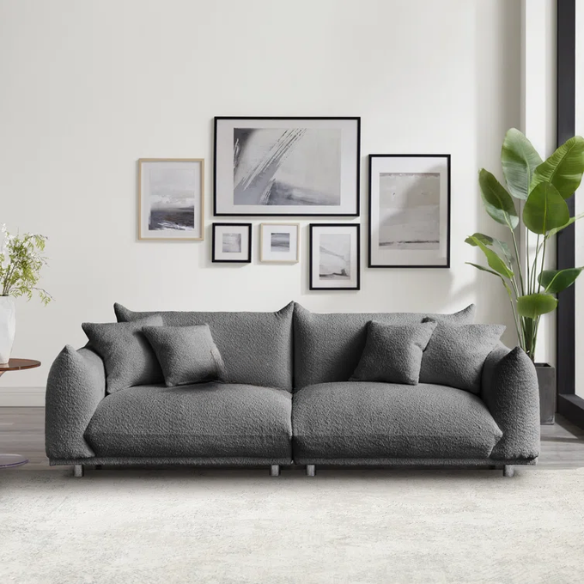 Modern 88.9-inch grey upholstered sofa with deep seat, rounded arms, chrome legs, and four matching accent pillows – ideal for contemporary living rooms or apartments.