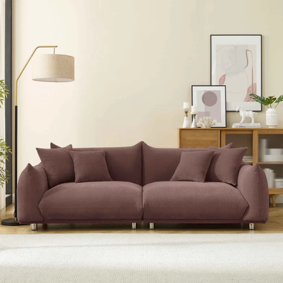 Modern muted brown upholstered sofa with deep seating and chrome-finished legs, featuring four matching accent pillows—ideal for warm, modern interiors.