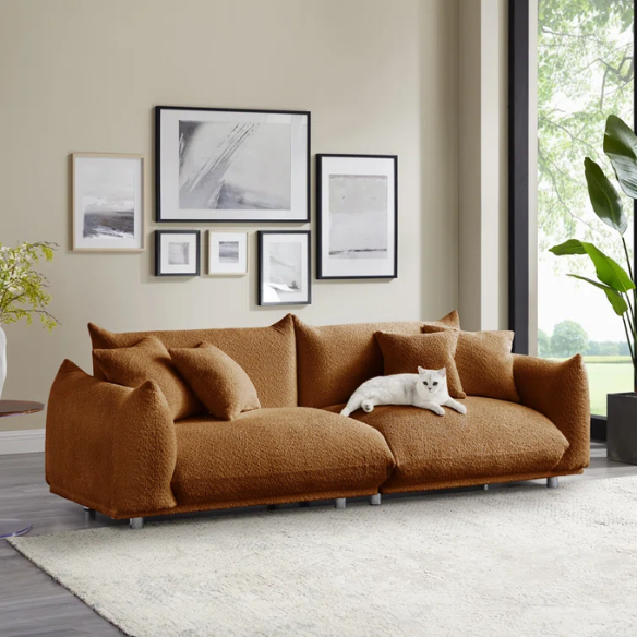 Modern rust brown upholstered sofa with deep seating and chrome-finished legs, featuring 4 matching accent pillows for a warm, stylish living room.
