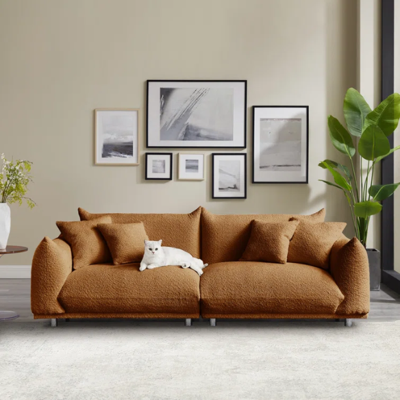 Modern rust brown upholstered sofa with deep seating and chrome-finished legs, featuring 4 matching accent pillows for a warm, stylish living room.