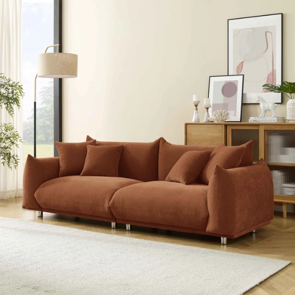 Modern rust upholstered sofa with deep seating and chrome-finished legs, featuring 4 matching accent pillows, perfect for contemporary living rooms.