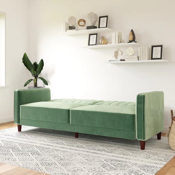 Muted green velvet convertible sofa featuring vertical tufting, square arms, split-back reclining design, and wood tapered legs with twin-size sleeper functionality.