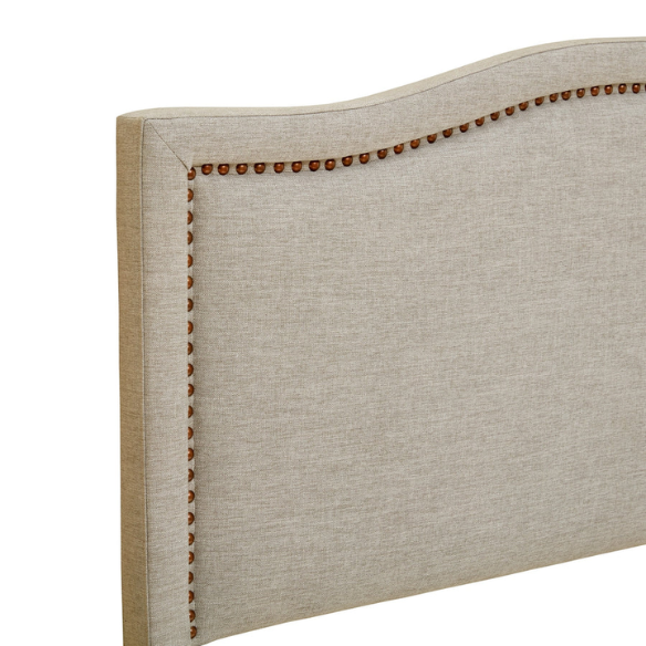 Natural beige upholstered king headboard with curved silhouette, silver nailhead trim, and adjustable metal legs for bed frame mounting