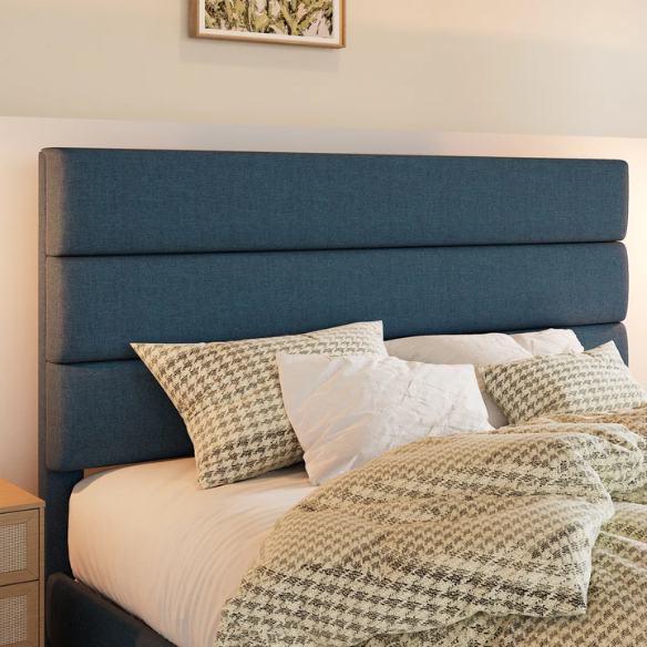 Navy blue king-size upholstered platform bed with rectangular headboard, padded linen-blend fabric, and slat support system