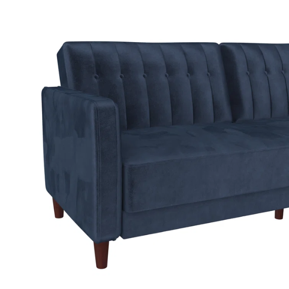 Navy blue velvet convertible sofa with vertical tufting, square arms, and brown tapered legs, designed with a split-back reclining feature and twin bed conversion.