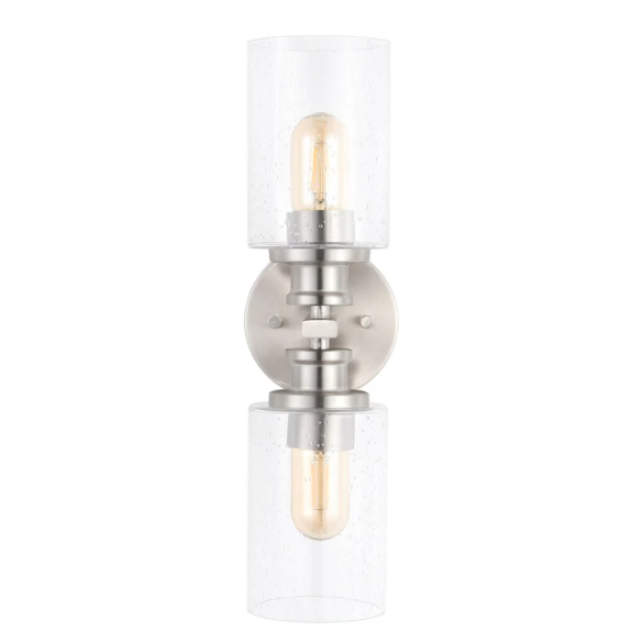 Brushed nickel wall sconce with two clear seeded glass cylinder shades and Edison-style LED bulbs, perfect for bathrooms or hallway accent lighting