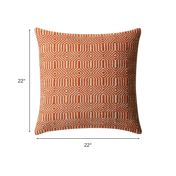 Orange and cream geometric throw pillow on a modern patio chair with bright outdoor decor