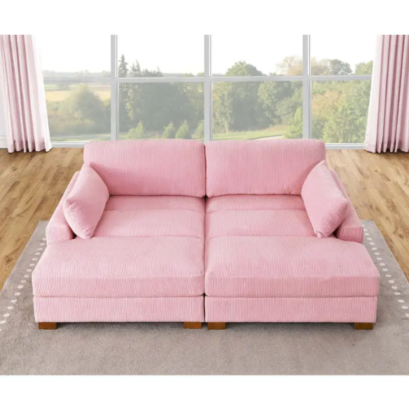 Pink corduroy convertible sleeper sofa with adjustable headrest, twin bed functionality, and mid-century wood legs