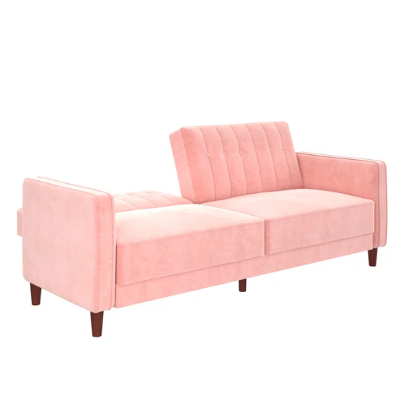 Pink velvet convertible sofa with tufted split-back design, square arms, and tapered brown wood legs, easily converting into a twin-size sleeper.