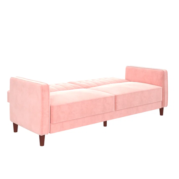 Pink velvet convertible sofa with tufted split-back design, square arms, and tapered brown wood legs, easily converting into a twin-size sleeper.