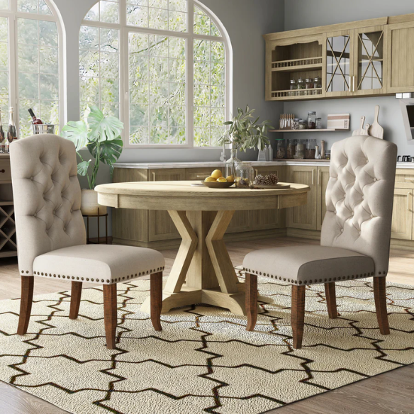 Set of 2 beige button-tufted farmhouse dining chairs with rustic wood legs, nailhead trim, and upholstered linen-like fabric.