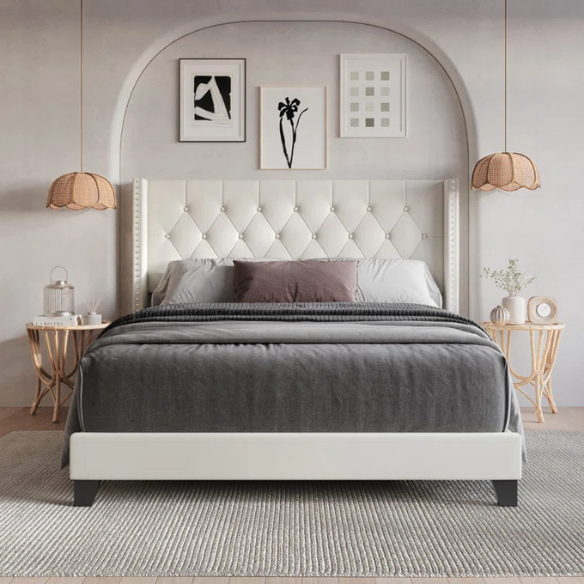 Beige full size upholstered platform bed with tufted wingback headboard, faux leather finish, and decorative nailhead trim on a solid wood frame.