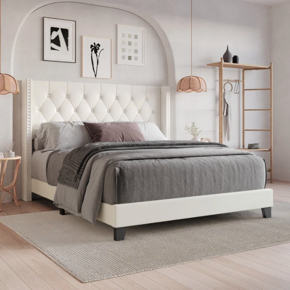 Beige full size upholstered platform bed with tufted wingback headboard, faux leather finish, and decorative nailhead trim on a solid wood frame.