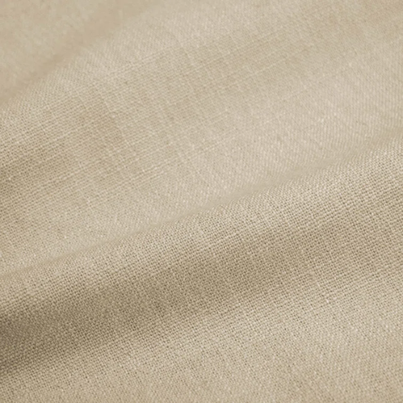Beige king-size upholstered bed in linen fabric with wingback headboard and low-profile black metal legs.