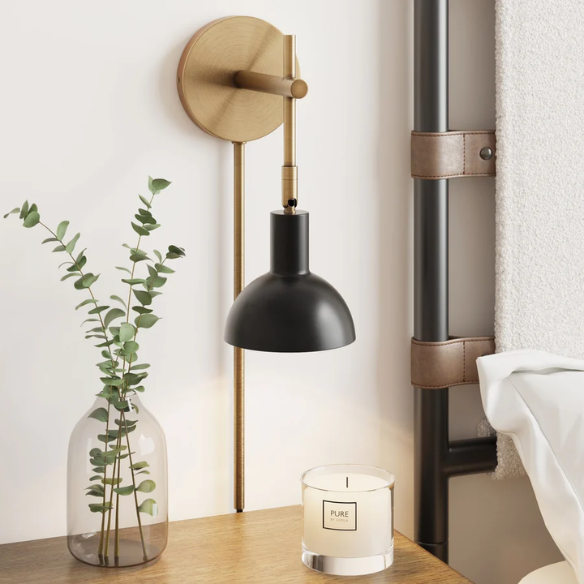Black and brass plug-in wall sconce with adjustable swing arm and bell-shaped brass shade, featuring built-in switch and cord cover for bedside or reading nook lighting
