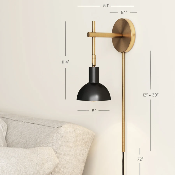 Black and brass plug-in wall sconce with adjustable swing arm and bell-shaped brass shade, featuring built-in switch and cord cover for bedside or reading nook lighting