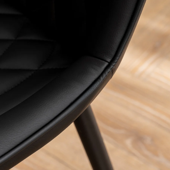 Set of 2 black faux leather dining chairs with fishtail backrest design and black metal legs, ideal for modern and contemporary dining spaces.