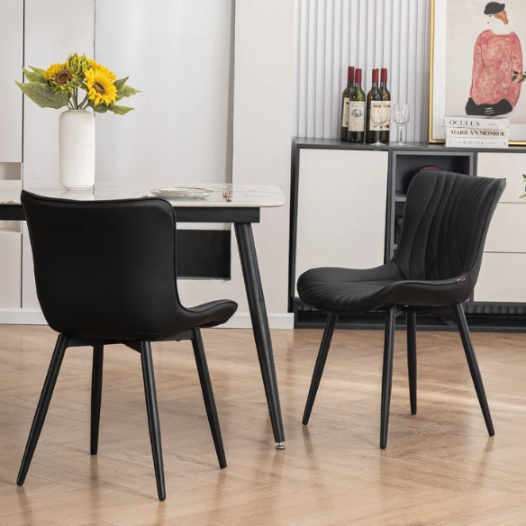 Set of 2 black faux leather dining chairs with fishtail backrest design and black metal legs, ideal for modern and contemporary dining spaces.