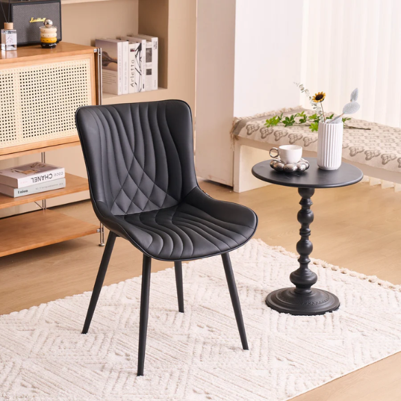 Set of 2 black faux leather dining chairs with fishtail backrest design and black metal legs, ideal for modern and contemporary dining spaces.
