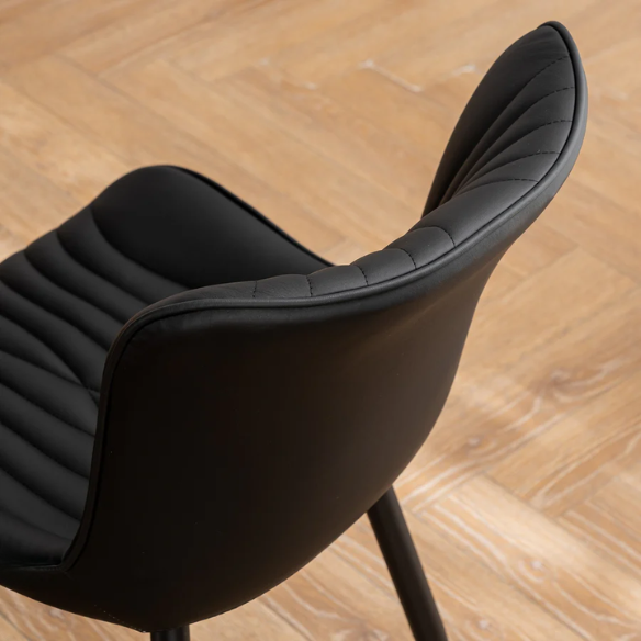 Set of 2 black faux leather dining chairs with fishtail backrest design and black metal legs, ideal for modern and contemporary dining spaces.