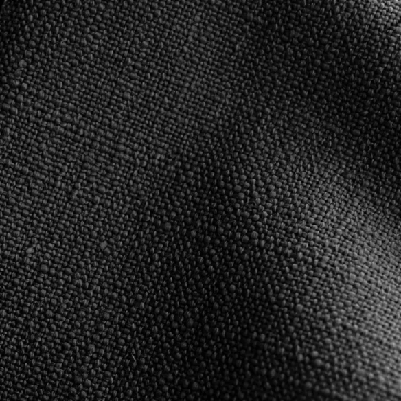 Black king-size upholstered bed in linen fabric with wingback headboard and low-profile black metal legs.