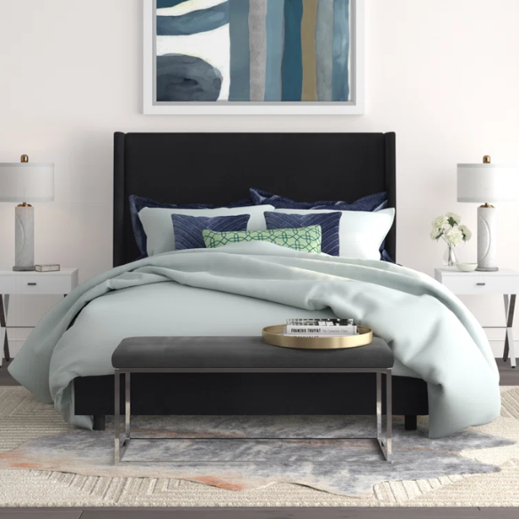Black king-size upholstered bed in linen fabric with wingback headboard and low-profile black metal legs.