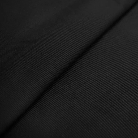 Black king-size upholstered bed in twill fabric with wingback headboard and low-profile black metal legs.