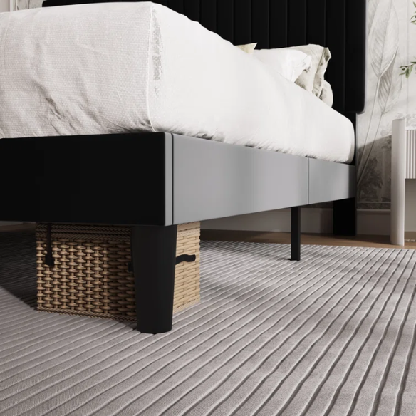 Black velvet upholstered queen bed with tufted wingback headboard and low-profile frame.