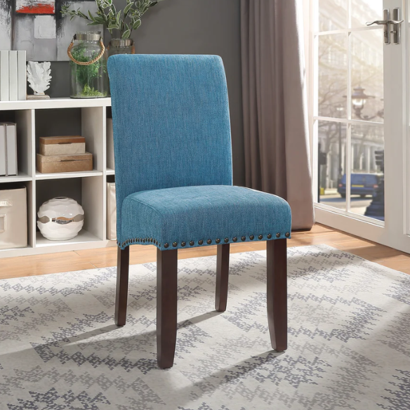 Blue denim upholstered Parsons chair with scrolled back, antique bronze nailhead trim, and solid wood legs