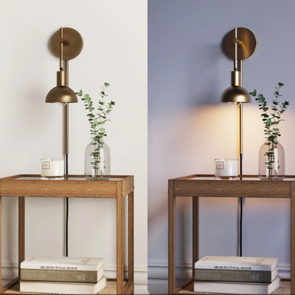 Brass plug-in wall sconce with adjustable swing arm and bell shade, featuring a built-in switch and cord cover for modern bedroom or reading nook lighting