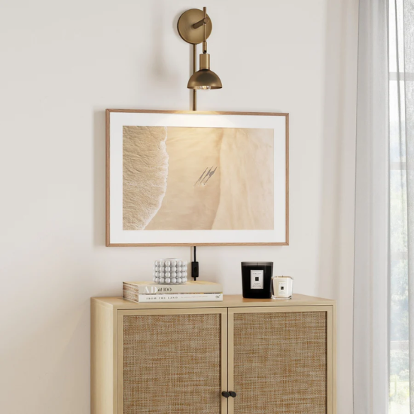 Brass plug-in wall sconce with adjustable swing arm and bell shade, featuring a built-in switch and cord cover for modern bedroom or reading nook lighting