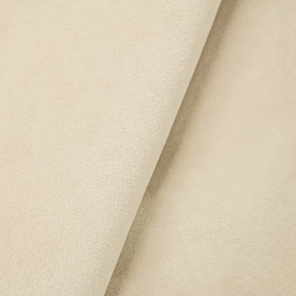 Cream king-size upholstered bed in velvet fabric with wingback headboard and low-profile black metal legs.