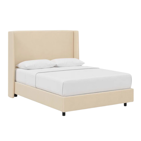Cream king-size upholstered bed in velvet fabric with wingback headboard and low-profile black metal legs.