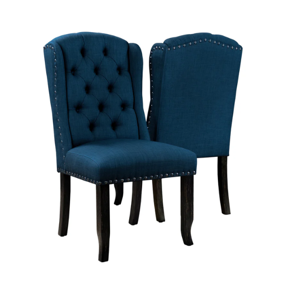 Set of two dark blue upholstered farmhouse dining chairs with tufted backs, brass nailhead trim, and antique black wood legs.