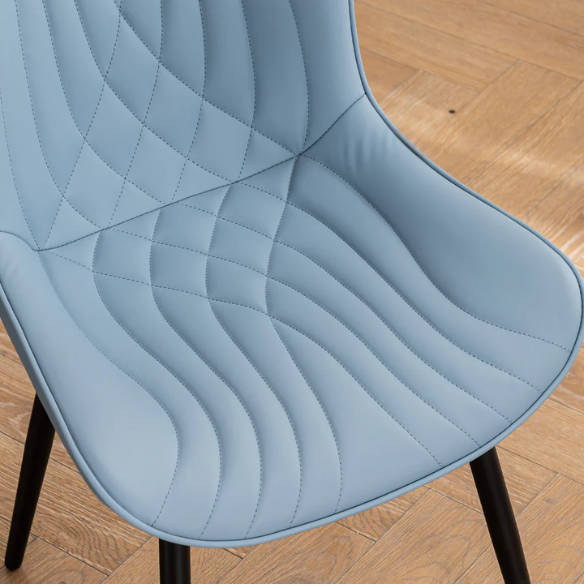 Set of 2 dusty blue faux leather dining chairs with fishtail tufted back and black metal legs, perfect for modern dining rooms or kitchen spaces.