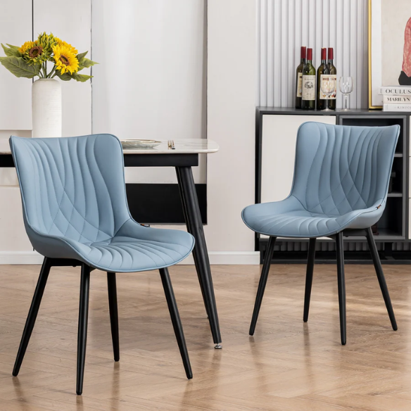 Set of 2 dusty blue faux leather dining chairs with fishtail tufted back and black metal legs, perfect for modern dining rooms or kitchen spaces.