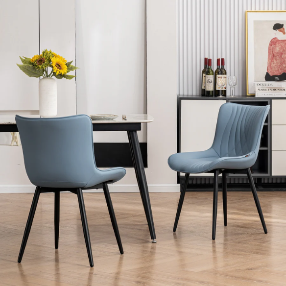 Set of 2 dusty blue faux leather dining chairs with fishtail tufted back and black metal legs, perfect for modern dining rooms or kitchen spaces.