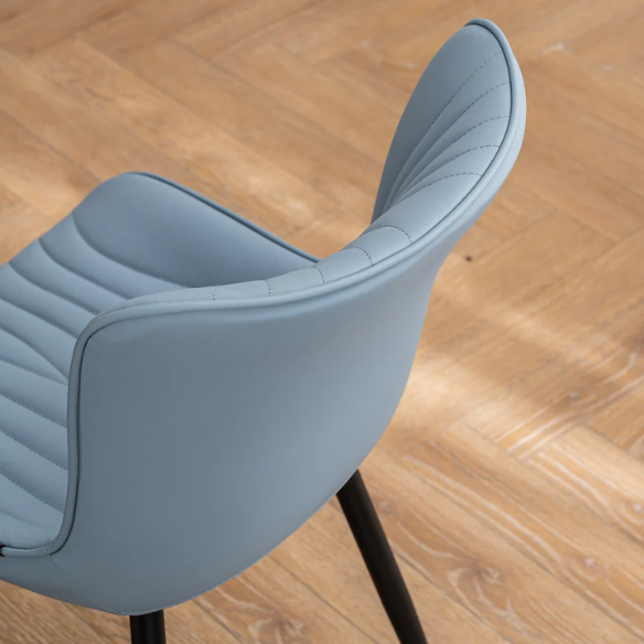 Set of 2 dusty blue faux leather dining chairs with fishtail tufted back and black metal legs, perfect for modern dining rooms or kitchen spaces.