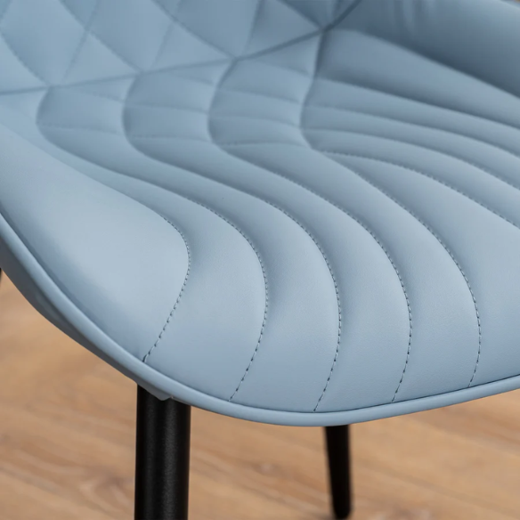 Set of 2 dusty blue faux leather dining chairs with fishtail tufted back and black metal legs, perfect for modern dining rooms or kitchen spaces.