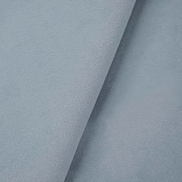 Dusty blue king-size upholstered bed in linen fabric with wingback headboard and low-profile black metal legs.