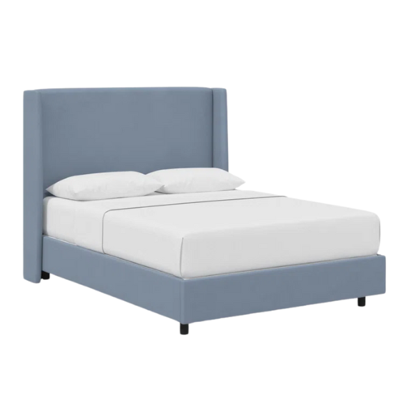 Dusty blue king-size upholstered bed in linen fabric with wingback headboard and low-profile black metal legs.