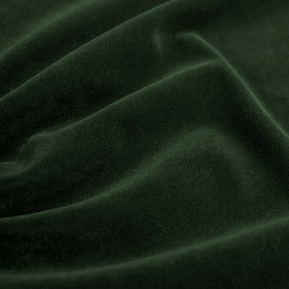 Emerald green king-size upholstered bed in velvet fabric with wingback headboard and low-profile black metal legs.